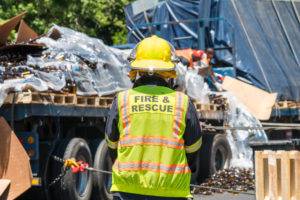 A rescue worker at a truck accident with glass bottles.