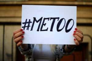 woman holding #metoo sign in front of face.