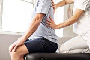 physical therapist helping male patient