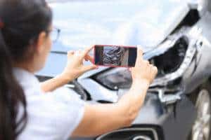 woman taking pictures of car damage