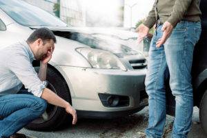 two men arguing after car accident